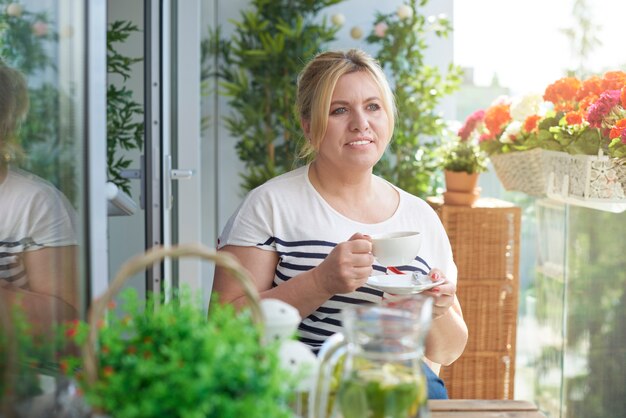 バルコニーでコーヒーを飲む女性の肖像画を閉じる