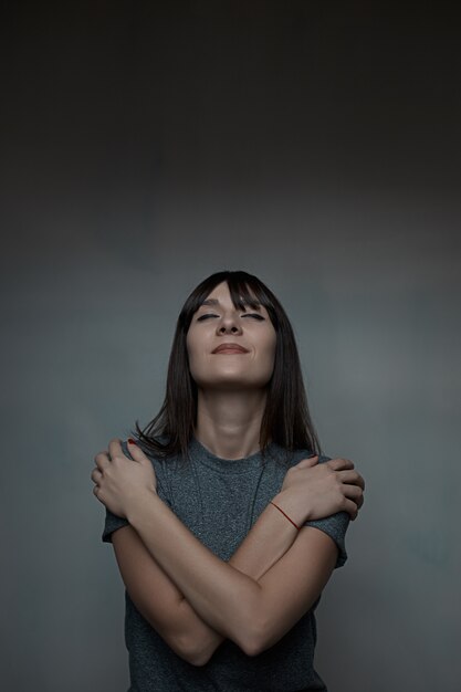 Close up portrait of woman embracing herself