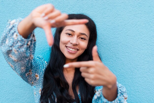 Close-up portrait of woman and frame made with hands