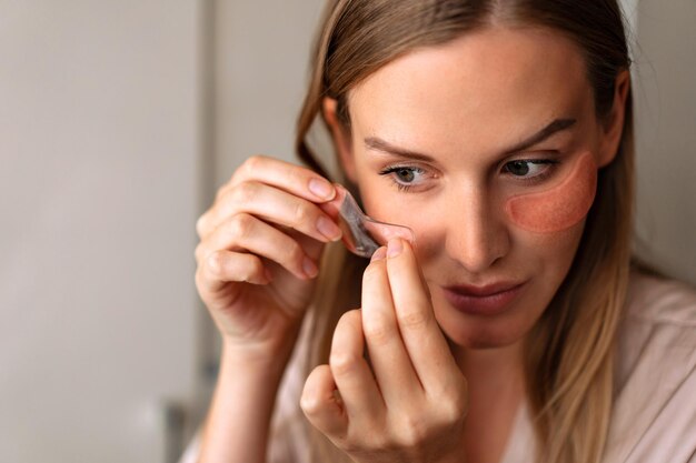 Close up portrait of woman using eye patches