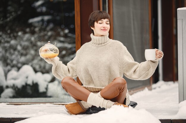 Free Photo close-up portrait of woman in white sweater, drinking tea