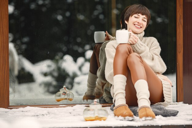 Free Photo close-up portrait of woman in white sweater, drinking tea