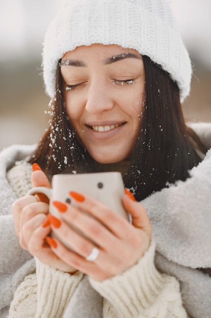 Foto gratuita ritratto del primo piano della donna in maglione bianco con tè