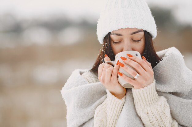 Free photo close-up portrait of woman in white sweater with tea