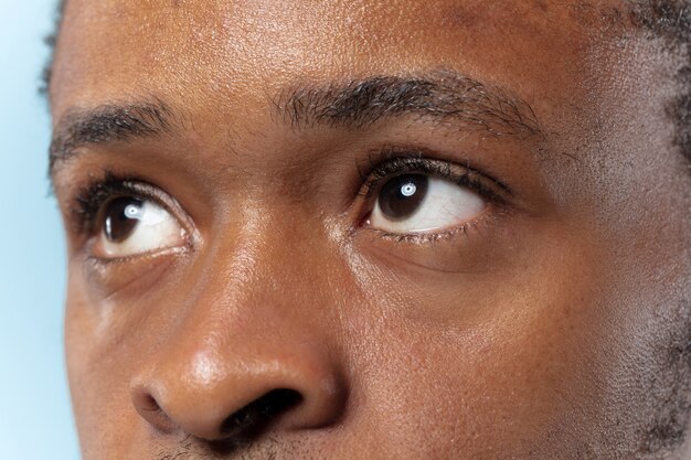 Close up portrait of young african-american man on blue space
