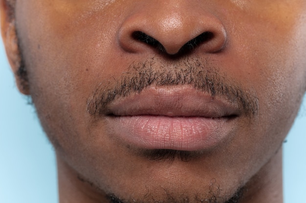 Close up portrait of young african-american man. Human emotions, facial expression, ad, sales or men's beauty and health concept.