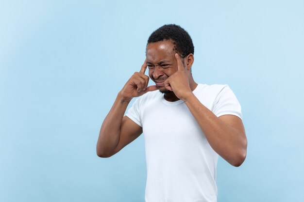 close up portrait of young african-american man in white shirt.. Suffering from headache, heavy thoughts, mental problems.