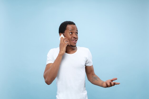 흰 셔츠에 젊은 아프리카 계 미국인 남자의 초상화를 닫습니다 ... 스마트 폰 들고 전화 통화.