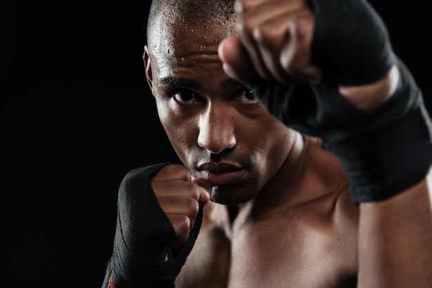 Close-up portrait of young afroamerican boxer, showing his fists
