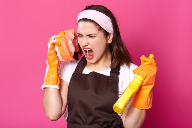 Close up portrait of young angry dark haired female wears headband