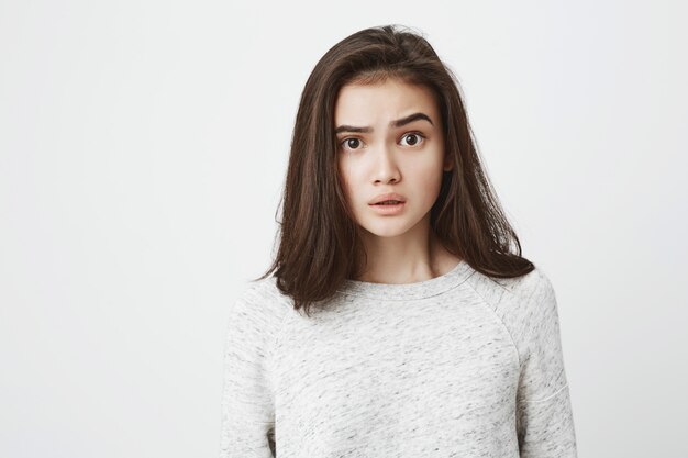 Close-up portrait of young attractive european adult brunette, lifting eyebrow with amazed and surprised expression.