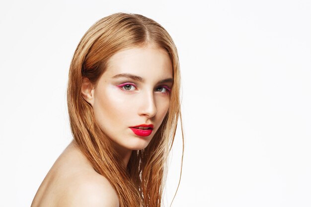 Close-up portrait of young beautiful confident girl with bright make up. . white wall. Isolated.