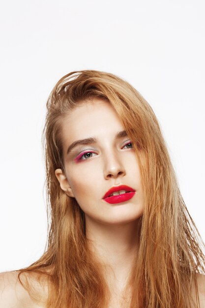 Close-up portrait of young beautiful sad confident girl with bright make up. white wall. Isolated.