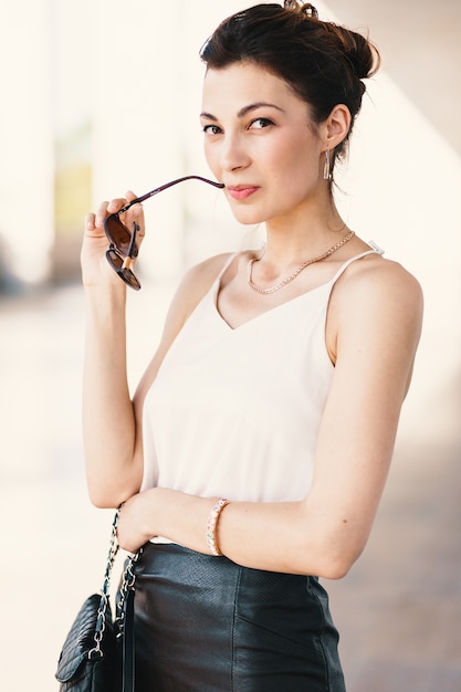 Close-up portrait of young, elegant brunette woman in cream silk