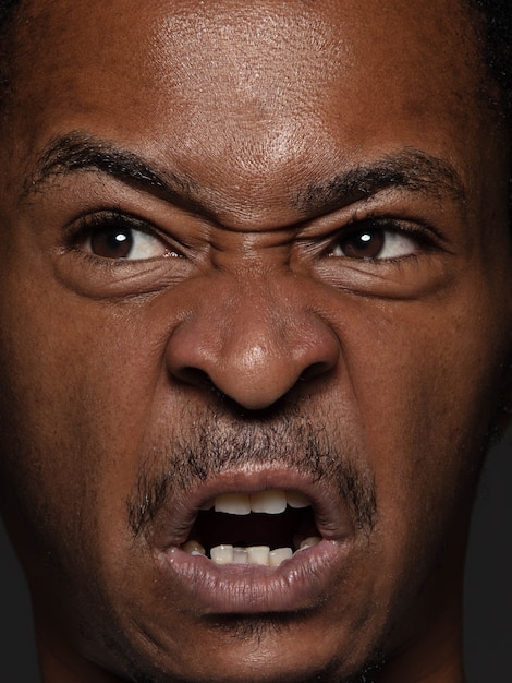 Free photo close up portrait of young and emotional african-american man. highly detail photoshot of male model with well-kept skin and bright facial expression. concept of human emotions. angry, agressive.