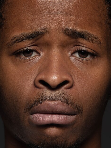 Закройте вверх по портрету молодого и эмоционального афро-американского человека. Детализированная фотосессия мужской модели с ухоженной кожей и выражением лица. Понятие о человеческих эмоциях. Расстроен, грустен, демотивирован.