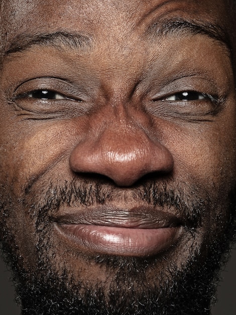 Close up portrait of young and emotional african-american man. male model with well-kept skin and bright facial expression. Concept of human emotions. Happy grimaces.