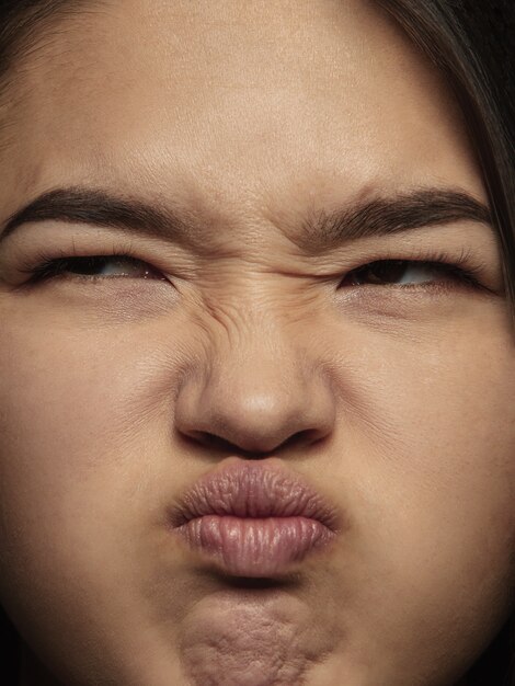 Close up portrait of young and emotional chinese woman. Highly detail photoshoot of female model with well-kept skin and bright facial expression. Concept of human emotions. Disgust.