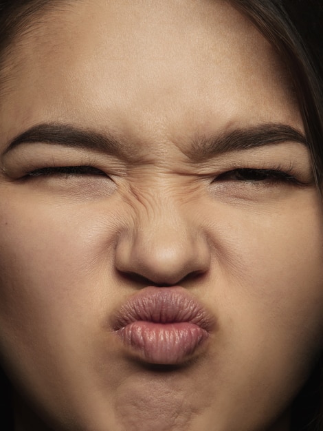 Free photo close up portrait of young and emotional chinese woman. highly detail photoshot of female model with well-kept skin and bright facial expression. concept of human emotions. playful, gremaces.