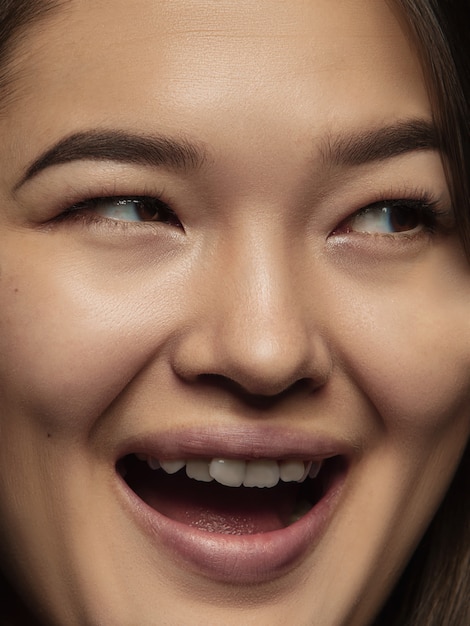 Закройте вверх по портрету молодой и эмоциональной китаянки. Детализированная фотосессия девушки-модели с ухоженной кожей и ярким выражением лица. Понятие о человеческих эмоциях. Улыбающийся, счастливый.