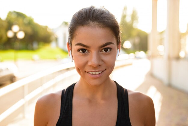 Close up portrait of a young fitness woman in earphones