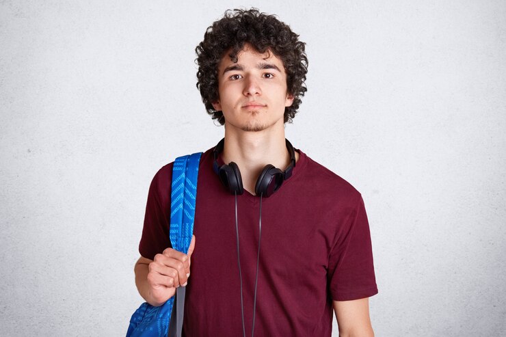 Free Photo close up portrait of young guy with curly hair