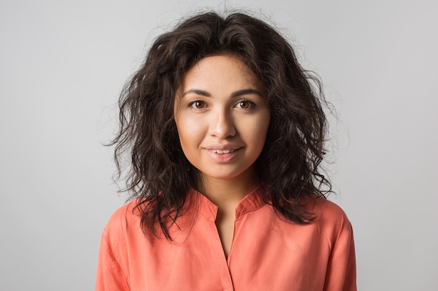 Close up portrait of young happy pretty brunette woman in orange shirt, curly hair, brown eyes, summer style, natural look, fashion trend, , mixed race, isolated, tanned skin