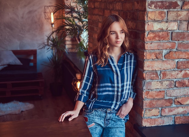 Free photo close-up portrait of a young hipster girl leaning against a bric