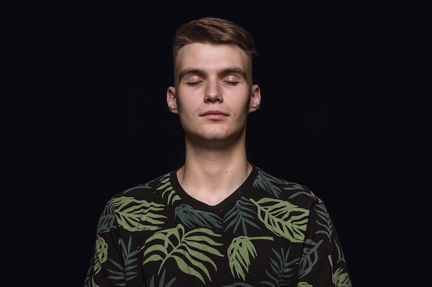 Free photo close up portrait of young man on black studio