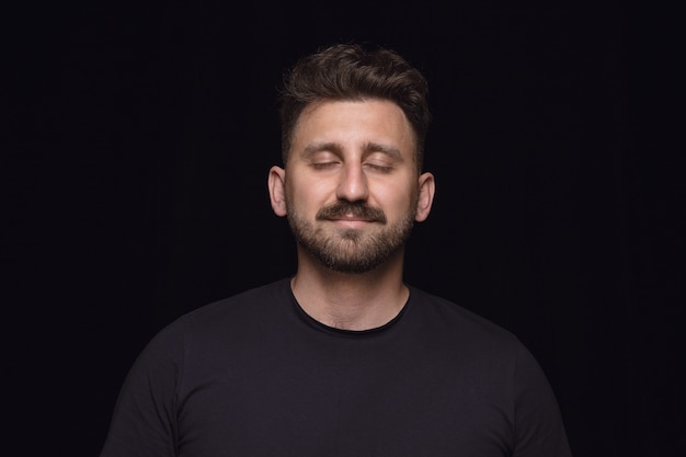 Free photo close up portrait of young man on black studio