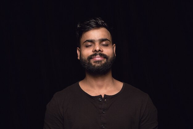 Free photo close up portrait of young man isolated on black studio wall