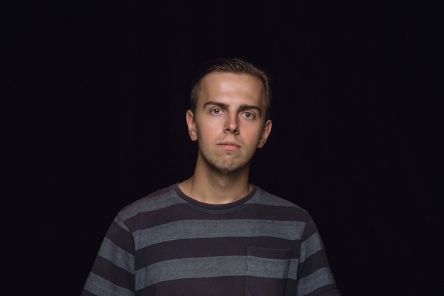 Free photo close up portrait of young man isolated on black wall