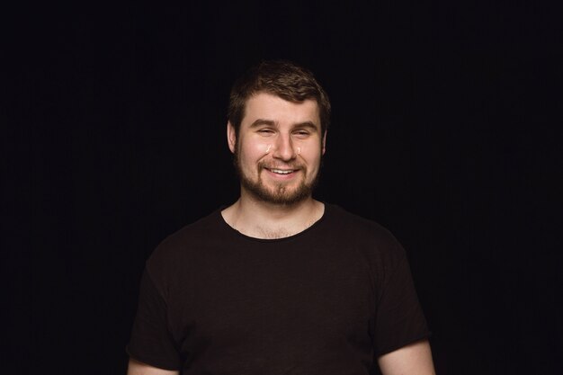 Close up portrait of young man isolated on black