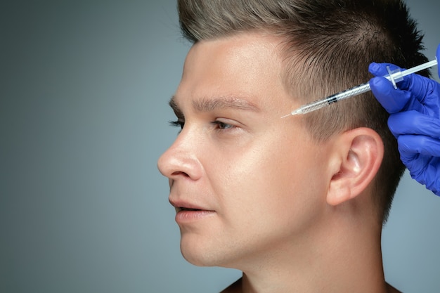 Close-up portrait of young man isolated on grey wall