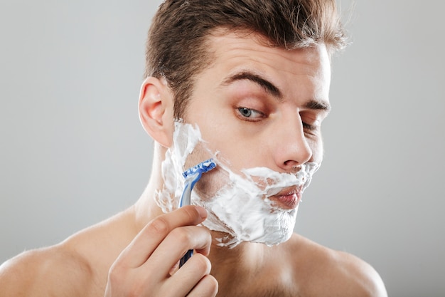 Close up portrait of a young man with shaving foam