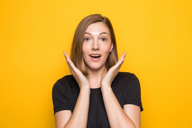 Close-up portrait of young pretty surprised woman with opened mouth standing with open palms