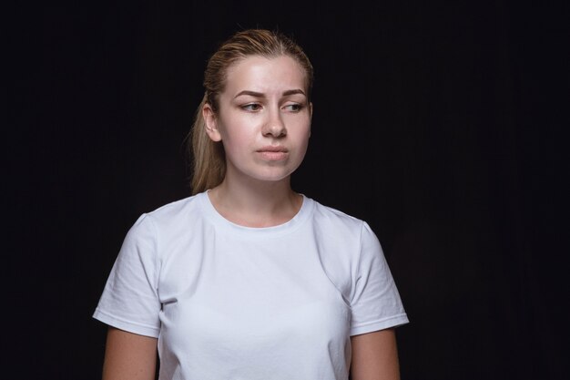 Close up portrait of young woman on black studio