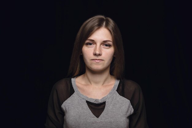 Close up portrait of young woman isolated on black studio background