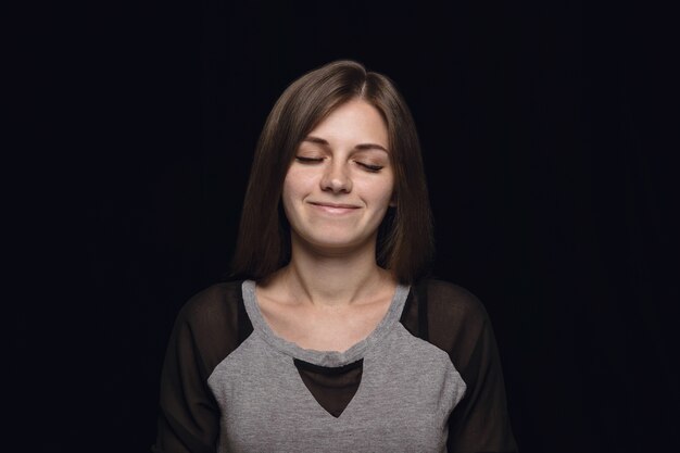 Close up portrait of young woman isolated. female model with closed eyes. Thinking and smiling. Facial expression, human emotions concept.