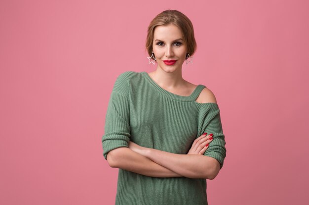 Close up portrait of young woman wearing a green sweater with red lips on pink