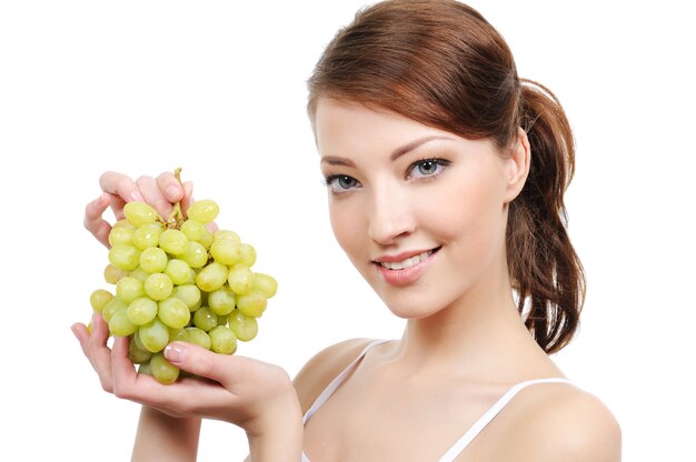 Close-up portrait of young woman with bunch of grapes
