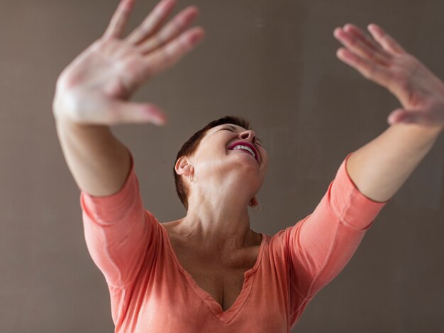 Close-up positive senior woman raising hands