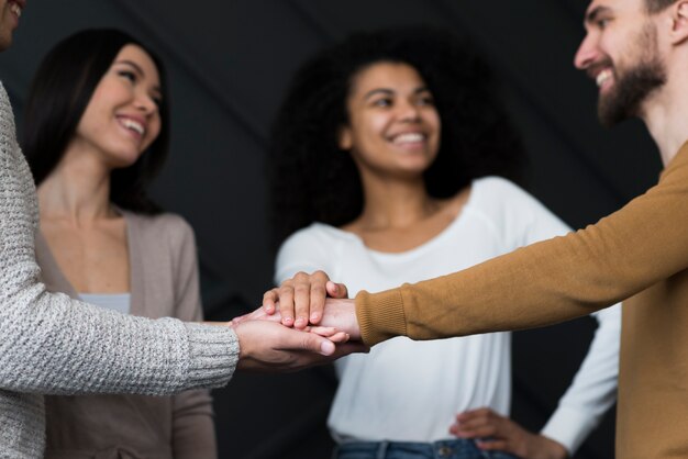 Close-up positive young people holding hands