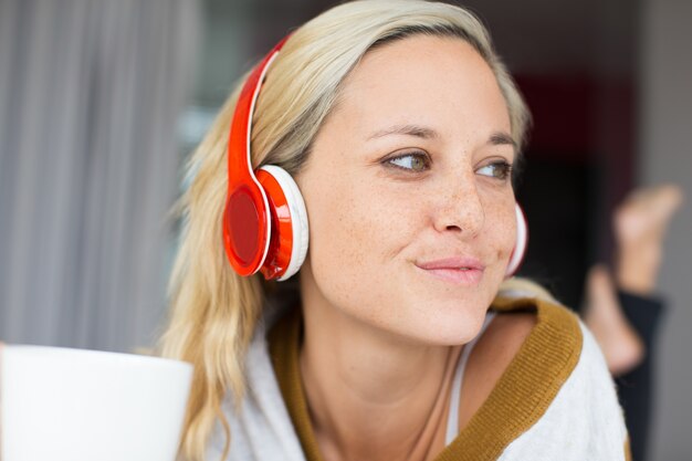 Close-up of positive young woman in headphones