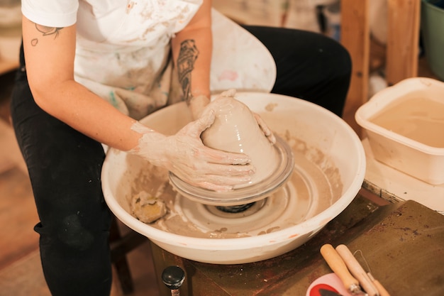 ホイール上の粘土を形作る陶工の手のクローズアップ
