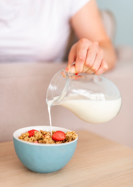 Close-up pouring milk in cereals