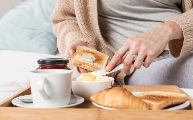 Foto gratuita donna incinta del primo piano che mangia brunch a letto