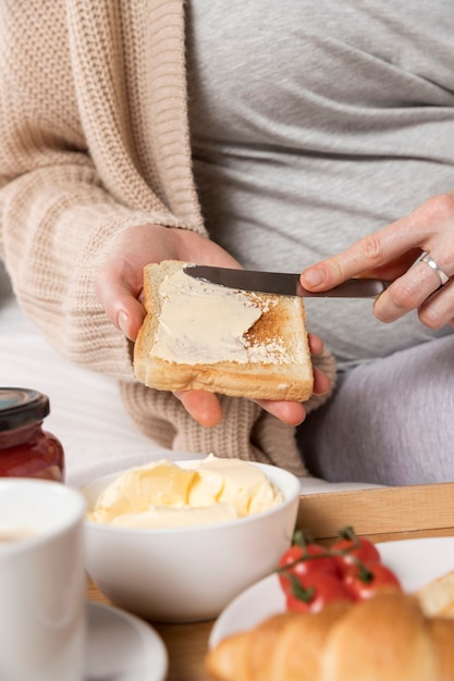 ブランチを家で食べるクローズアップ妊娠中の女性