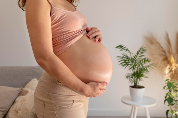 Close up pregnant woman holding belly