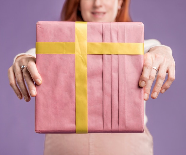 Close-up pregnant woman holding gift
